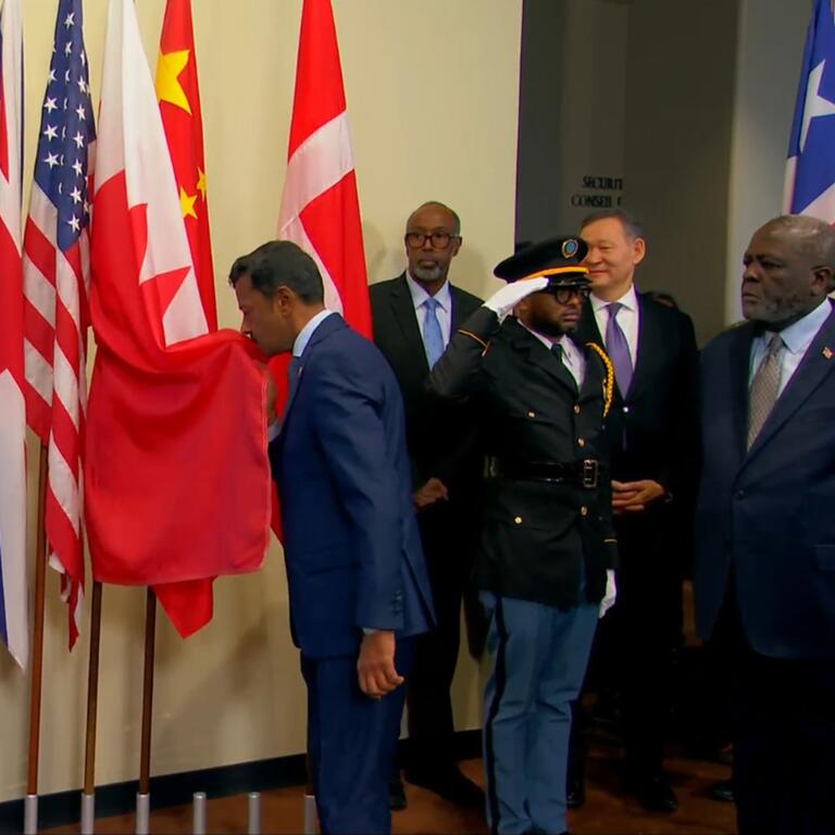 السفير جمال فارس الرويعي الممثل الدائم لمملكة البحرين لدى الأمم المتحدة يُقبل علم بلاده، أثناء مراسم رفع أعلام الدول الخمس التي انضمت إلى عضوية مجلس الأمن بدءا من الأول من يناير 2026.